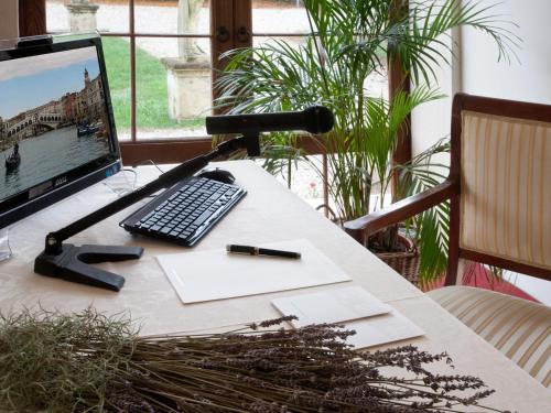 a desk with a computer and a keyboard and a microphone at Hotel Villa Cornér Della Regina in Vedelago