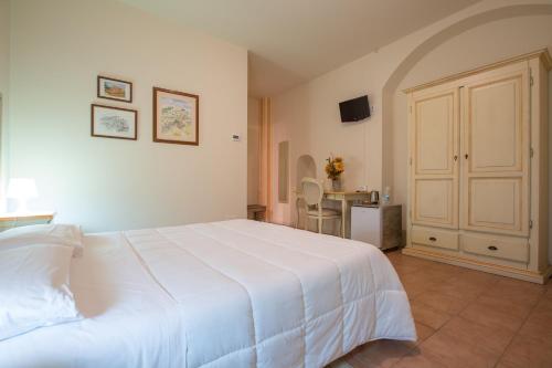 Un dormitorio con una gran cama blanca y una mesa en Camere Centro Storico en Canelli
