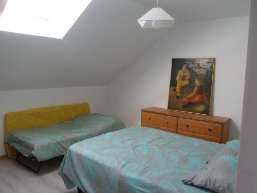 a bedroom with two beds and a painting on the wall at L'etape de St Hilaire La Gravelle in Saint-Hilaire-la-Gravelle