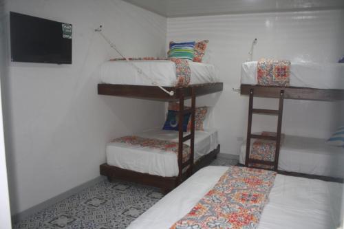 a room with three bunk beds and a flat screen tv at Olas Del Caribe in San Andrés