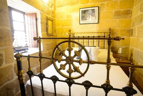 a bedroom with a bed in a stone wall at The Burrow Guest House in Tarxien