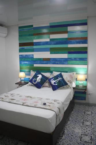 a bedroom with a bed with a colorful wall at Olas Del Caribe in San Andrés