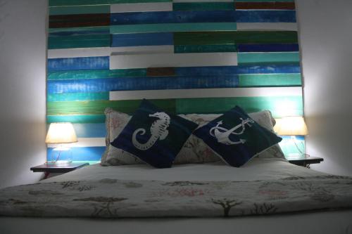 a bed with two pillows on it with two lamps at Olas Del Caribe in San Andrés