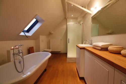 een grote badkamer met een bad en een wastafel bij De Sneppelhoeve in Wuustwezel
