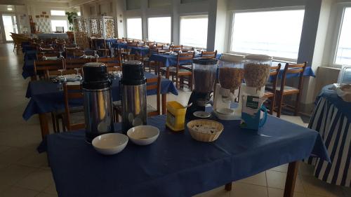 a table with a blue table cloth with bottles and bowls at Hotel Apartamento Praia Azul in Santa Cruz
