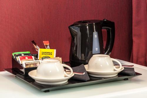 a tray with a coffee pot and cups on a table at Culture Hotel Centro Storico in Naples