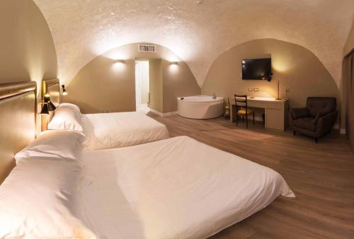 a room with two beds and a bathroom with a tub at Caruso Place Boutique & Wellness Suites in Naples