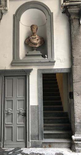 a stairway with a statue of a bust next to a building at Caruso Place Boutique & Wellness Suites in Naples