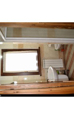 a bathroom with a window and a sink and a toilet at Agricola Lanciani in Montefiore dellʼAso