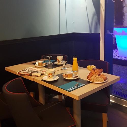 カンペールにあるHotel De La Gareの食べ物と飲み物の盛り合わせが付いたテーブル