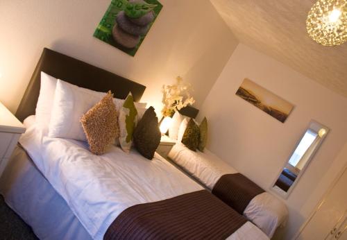 a bedroom with two beds and a chandelier at Carron House Holiday Apartments in Skegness