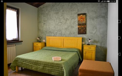 a bedroom with a bed with a green bedspread at Agricola Lanciani in Montefiore dellʼAso