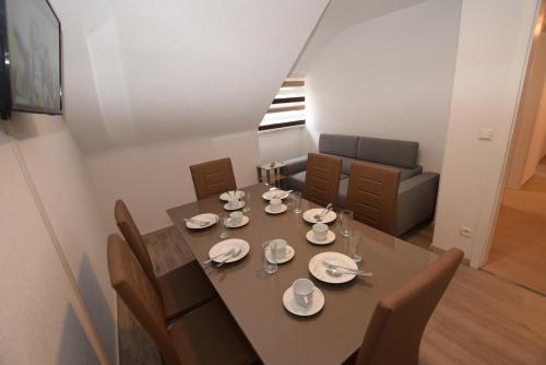 a dining room with a table and chairs with plates and bowls at Apartment Hedelfingen I in Stuttgart