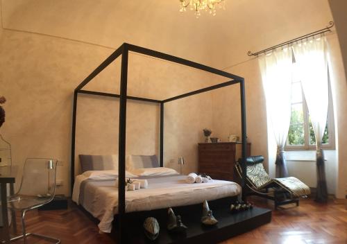 a bedroom with a canopy bed and a chair at Villa Pieve De' Pitti in Terricciola