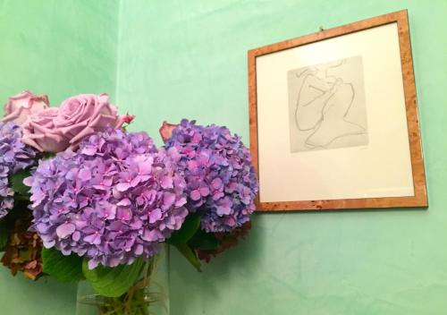 a vase filled with purple flowers next to a picture at Villa Pieve De' Pitti in Terricciola