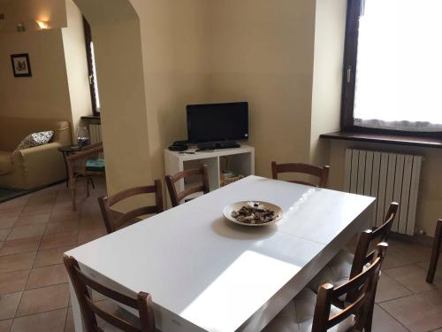 a living room with a white table and a television at casa vacanze il gelsomino in Nocera Umbra
