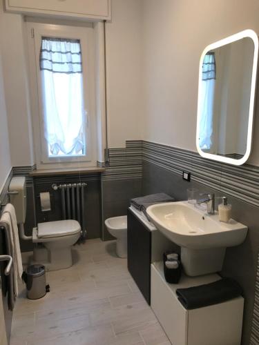 a bathroom with a sink and a toilet and a mirror at Appartamenti Giada in Verona