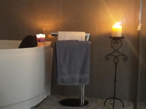 a bathroom with a candle and a towel on a tub at Door Eight in Il-Furjana