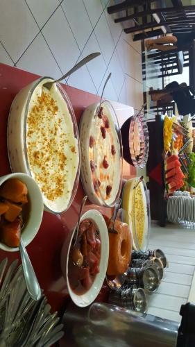a group of bowls of food on a counter at Hotel Pousada Por do Sol in Protásio Alves