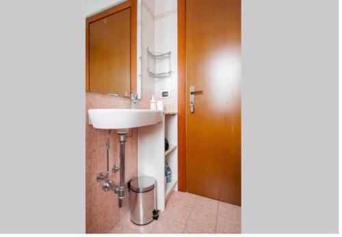Łazienka z umywalką i drewnianymi drzwiami w obiekcie Apartment Forum 2 w mieście Assago