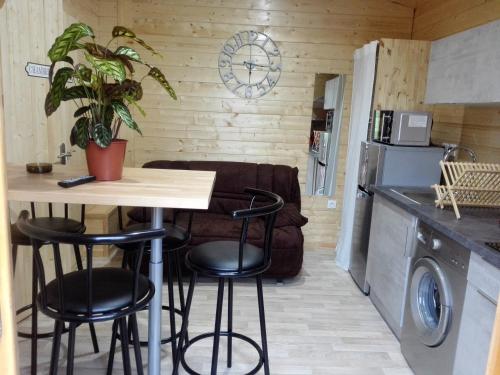 a kitchen with a table and stools in a room at Le chalet douillet in Saint-Geniès