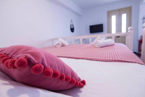 two twin beds with pink pillows on them in a bedroom at Aegli Apartments in Symi
