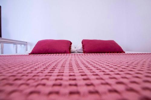 a bed with two purple pillows on top of it at Aegli Apartments in Symi