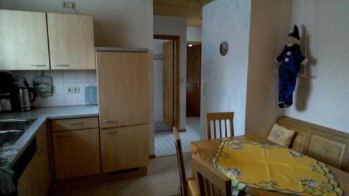 a kitchen with a small table and a kitchen with a doll on the wall at Apartment Meyerhof in Schwanau