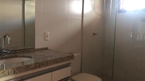 a bathroom with a shower and a sink and a toilet at Baleia Branca Chalé in Porto Belo