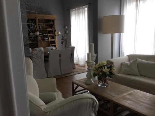 ein Wohnzimmer mit weißen Stühlen und einem Tisch in der Unterkunft Al Massimo 36 in Palermo