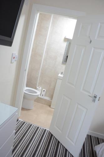 a bathroom with a toilet and a white door at The Oxfordshire in Blackpool