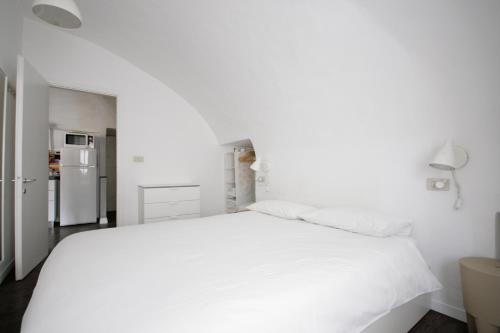 トリノにあるAppartamento Quadrilatero Romanoの白いベッドルーム(白いベッド1台、冷蔵庫付)