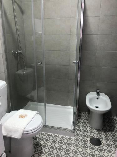 a bathroom with a shower and a toilet and a sink at Soldouro Guesthouse in Aveiro