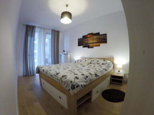 a bedroom with a bed in a room with a window at Apartament Obrzeżna 3 Deluxe in Warsaw