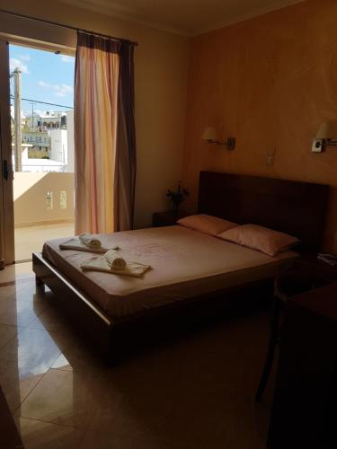 a bedroom with a large bed with a window at Rastoni Apartments in Kissamos