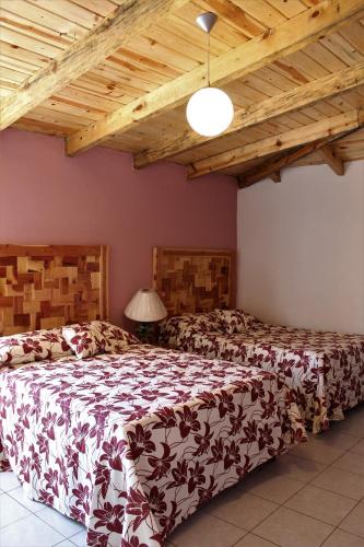 a bedroom with a large bed and a wooden ceiling at Villas La Quinta in Creel