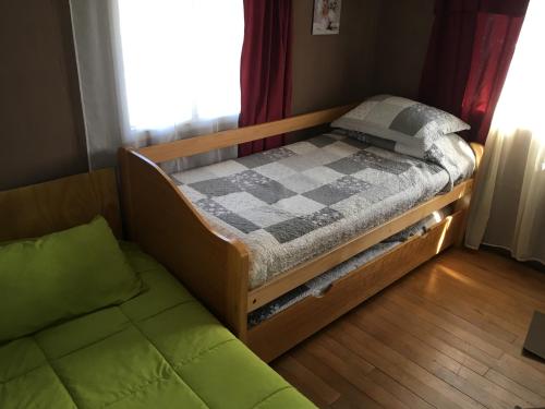 1 cama y 1 sofá en una habitación con ventana en Hospedaje Lago Llanquihue, en Llanquihue
