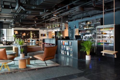 a lobby of a restaurant with chairs and tables at Comfort Hotel Västerås in Västerås