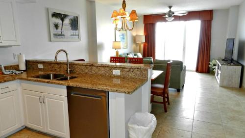 a kitchen with a sink and a living room at 2 BR Resort Condo Direct Oceanfront Wyndham Ocean Walk - Daytona Funland 2226 in Daytona Beach