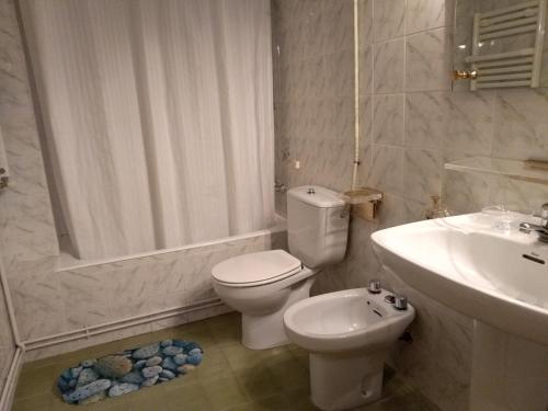 Un baño blanco con inodoro y lavabo. en La Luna de Alicante, en Alicante