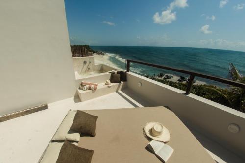 a balcony with a table and a view of the ocean at Maria Del Mar Tulum - Adults Only in Tulum