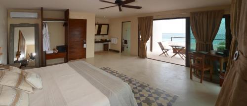 a bedroom with a bed and a dining room with a table at Maria Del Mar Tulum - Adults Only in Tulum
