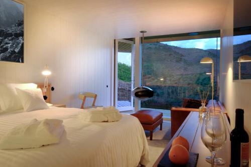 a bedroom with a bed and a large window at Casa do Rio Wine Hotel - Vallado in Vila Nova de Foz Coa