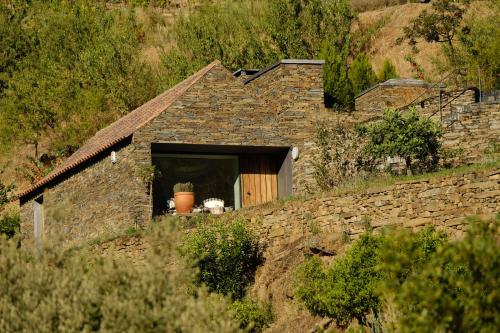 a stone house with a window on a hill at Casa do Rio - Douro Wine Hotel by Vallado in Vila Nova de Foz Coa