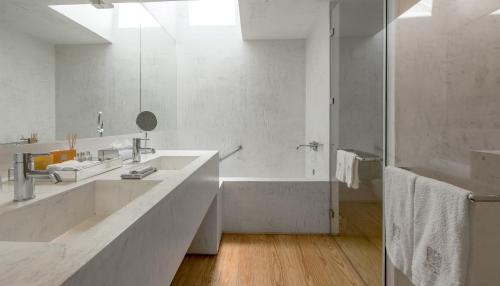 a white bathroom with two sinks and a shower at Casa do Rio - Douro Wine Hotel by Vallado in Vila Nova de Foz Coa