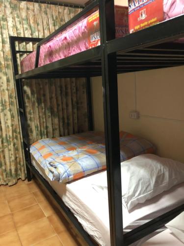 two bunk beds in a room with a bed at Dikachaya Hostel in Chaweng