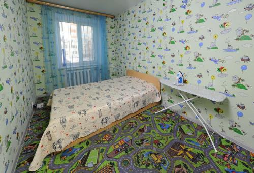 オムスクにあるOmsk Sutki Apartments at Pushkina 99 floor 3のベッドルーム1室(ベッド1台付)が備わります。壁には漫画が飾られています。