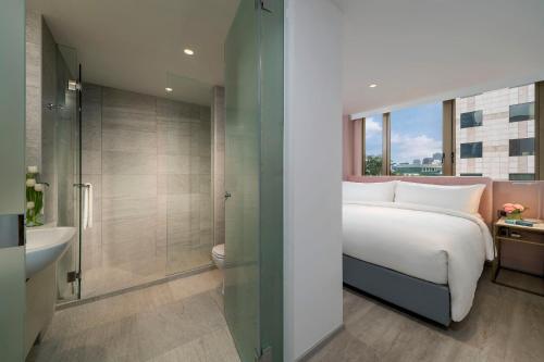 a bedroom with a bed and a bathroom with a shower at Lanson Place Winsland, Singapore in Singapore