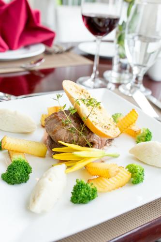 a plate of food with meat and vegetables on a table at TTC Hotel - Ngoc Lan in Da Lat