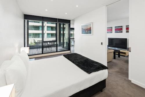 1 dormitorio blanco con 1 cama grande y TV en Edgewater 207 en Geelong